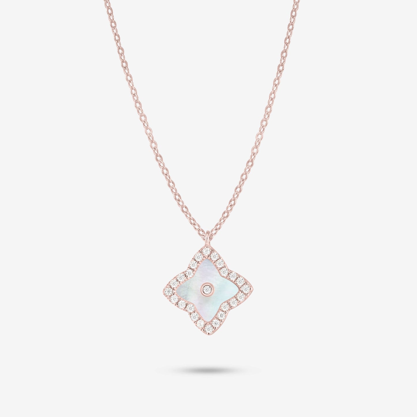 Studio shot of the Rose Gold Irida Necklace styled with a luminous mother-of-pearl quatrefoil pendant, surrounded by a moissanite halo and central stone on a gray background.