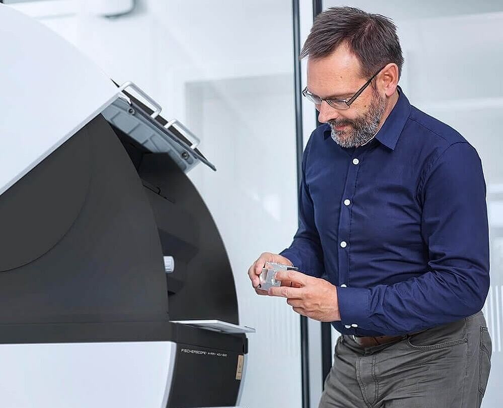 An expert at an independent certification facility uses an XRF analyser to verify the metal purity of our demi-fine jewellery.