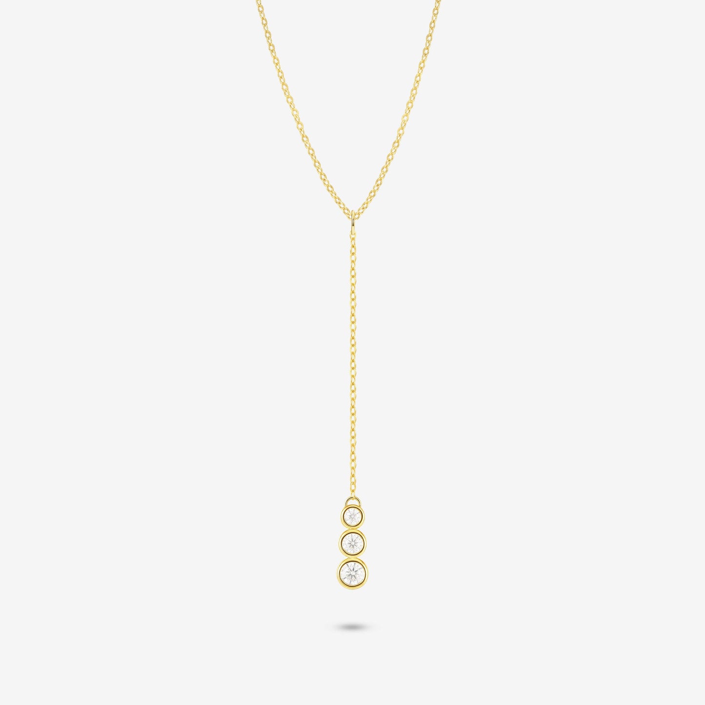 Studio shot of the Gold Astral Necklace featuring a lariat Y-necklace design with three vertically aligned bezel-set moissanites in a drop pendant on a light grey background
