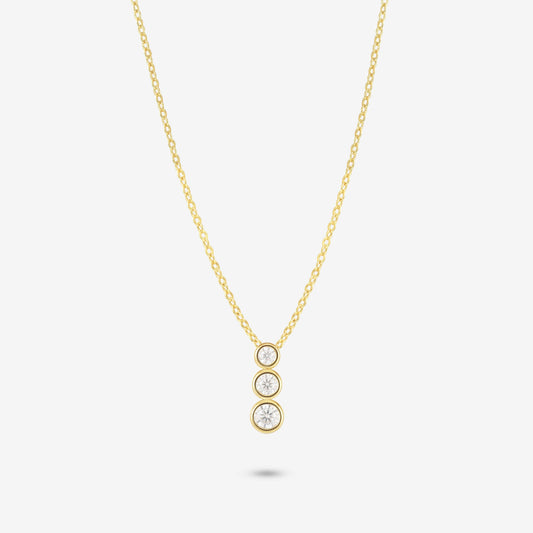 Studio shot of the Gold Aviel Necklace featuring three round bezel-set moissanite stones in a vertical drop, on a light grey background