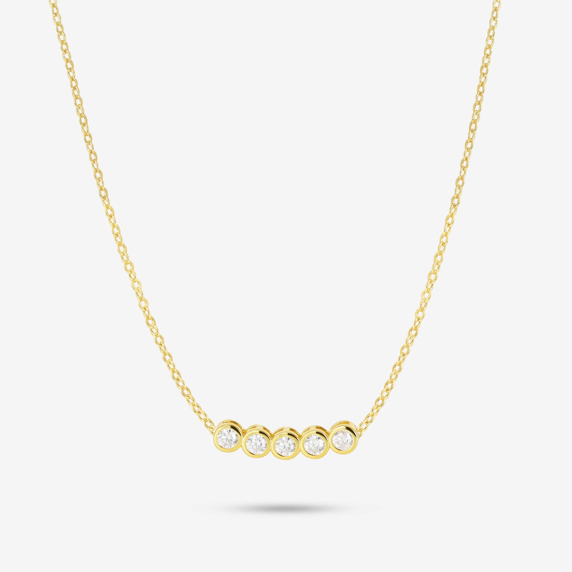 Studio shot of the Gold Dawn Necklace featuring five round bezel-set moissanites aligned horizontally on a delicate yellow gold chain, displayed on a light grey background