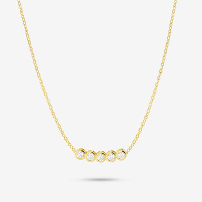 Studio shot of the Gold Dawn Necklace featuring five round bezel-set moissanites aligned horizontally on a delicate yellow gold chain, displayed on a light grey background