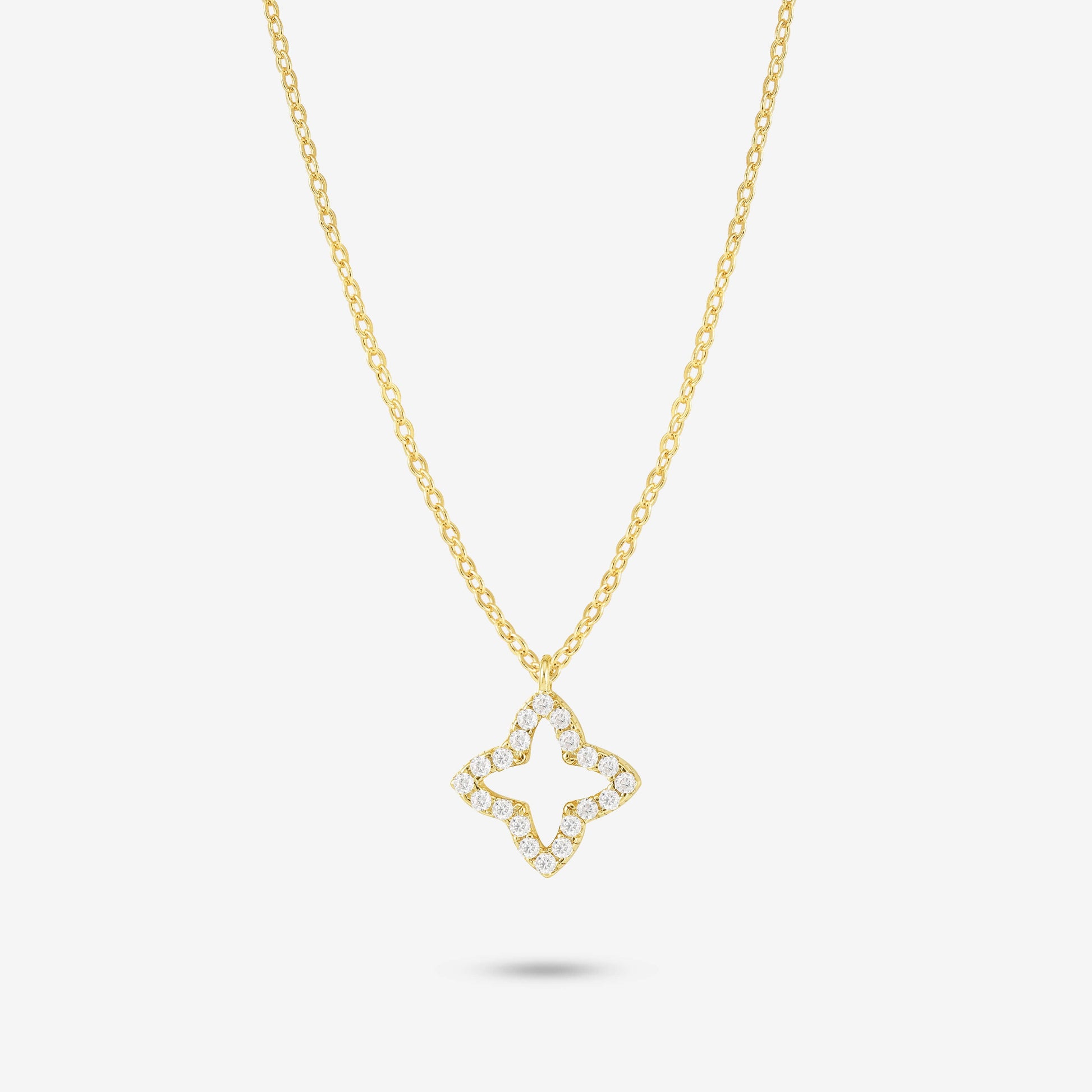Studio shot of the Gold Eden Necklace showcasing an openwork flower-shaped pendant set with moissanites on a yellow gold chain, presented on a neutral grey background
