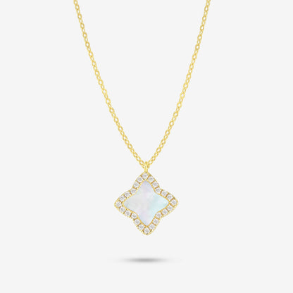 Studio shot of the Gold Edea Necklace with a clover-shaped pendant framed by moissanites and iridescent mother-of-pearl, photographed on a plain grey backdrop