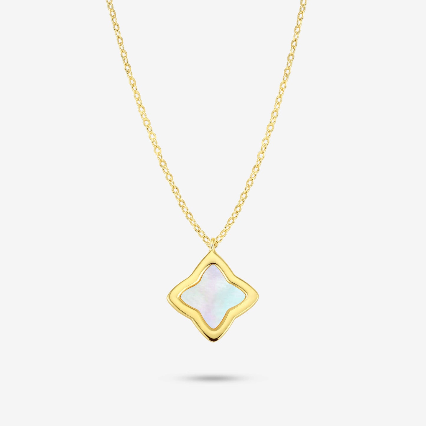 Studio shot of the Gold Creia Necklace with a flower-shaped pendant and iridescent mother-of-pearl inlay on a grey background