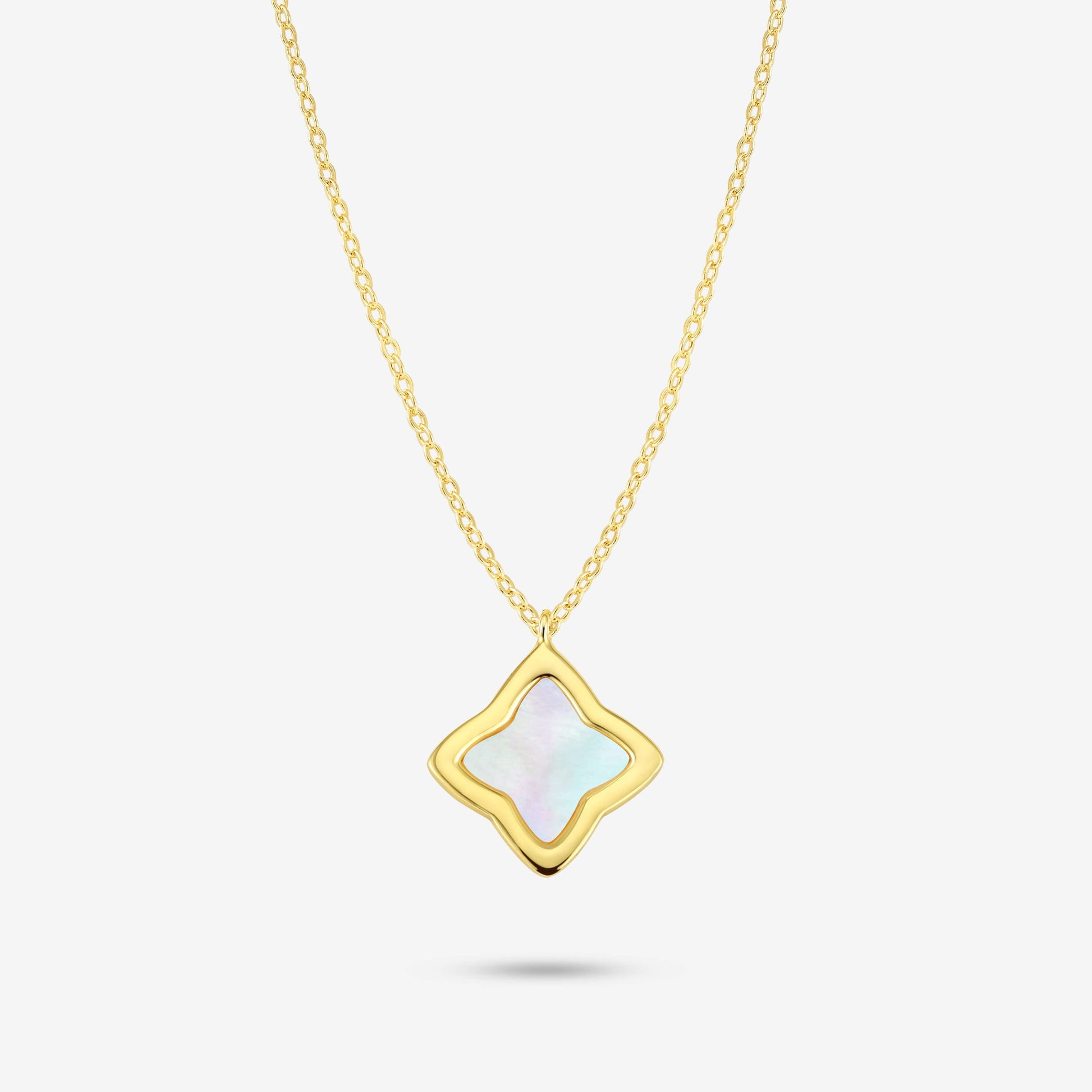 Studio shot of the Gold Creia Necklace with a flower-shaped pendant and iridescent mother-of-pearl inlay on a grey background
