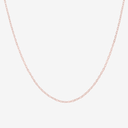 Studio shot of a 18k rose gold cable chain necklace, shown on a neutral grey backdrop