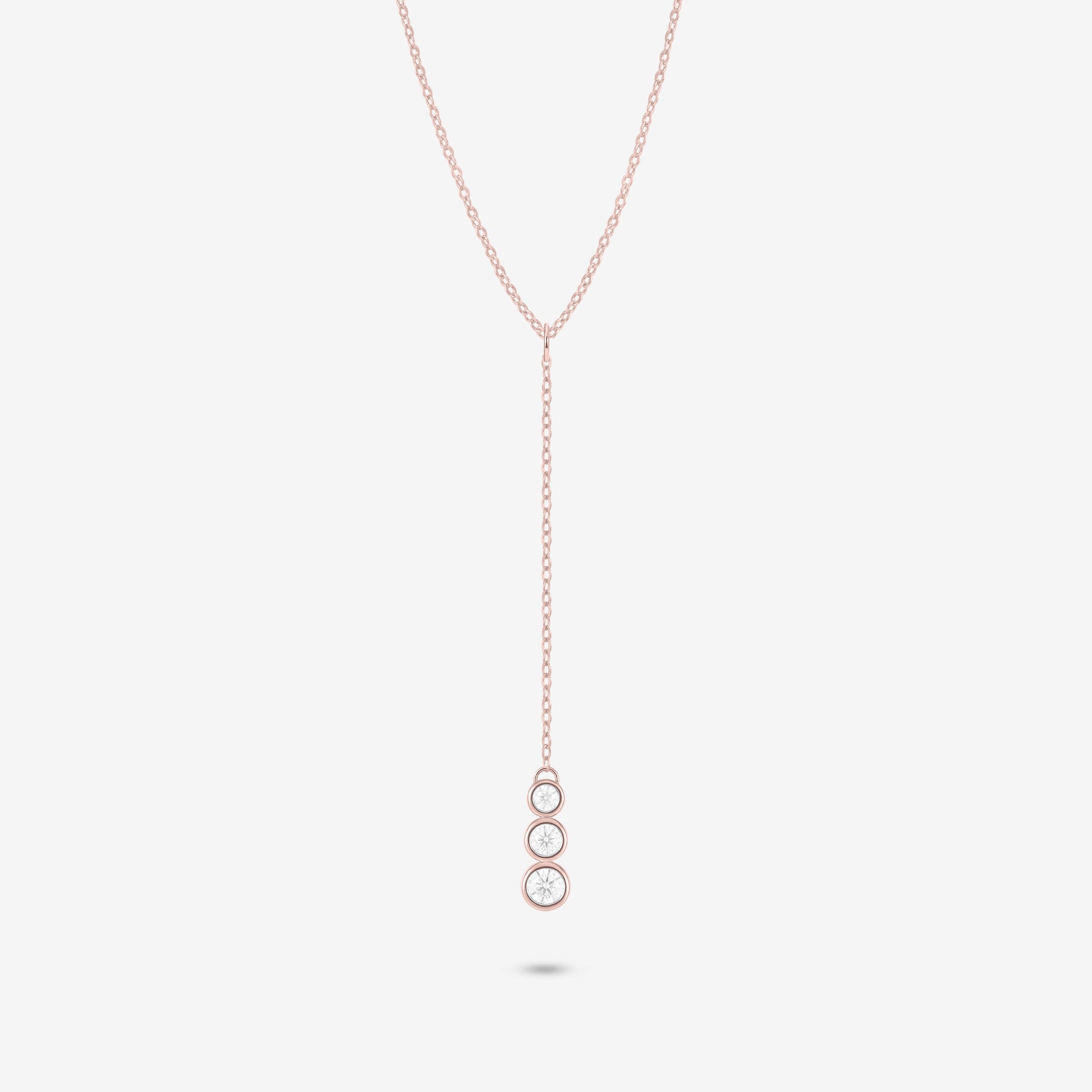 Studio shot of the Rose Gold Astral Necklace with a trio of graduated bezel-set moissanites in a vertical drop pendant design, shown against a neutral grey background