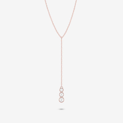 Studio shot of the Rose Gold Astral Necklace with a trio of graduated bezel-set moissanites in a vertical drop pendant design, shown against a neutral grey background