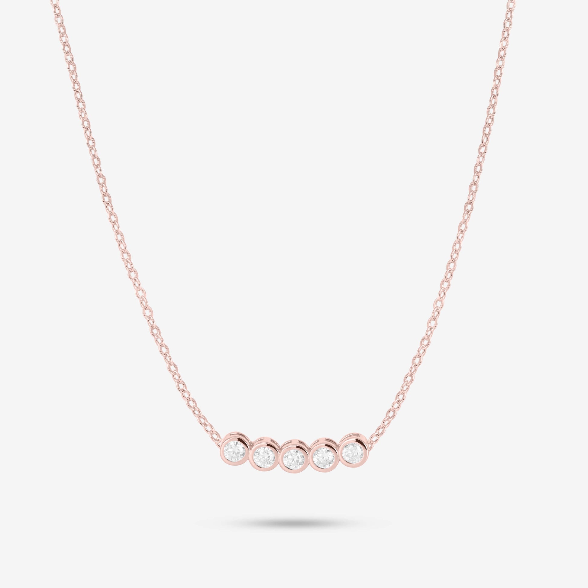 Studio shot of the Rose Gold Dawn Necklace with five bezel-set moissanites in a horizontal row on a fine rose gold chain against a neutral grey backdrop