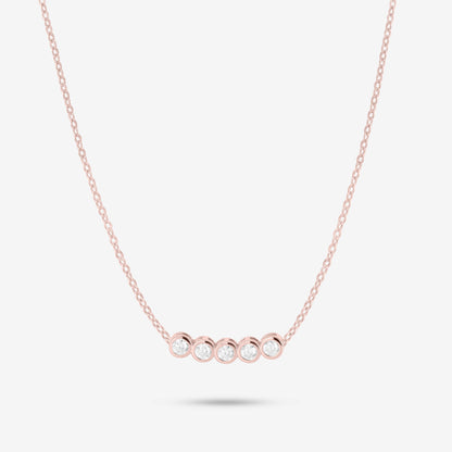 Studio shot of the Rose Gold Dawn Necklace with five bezel-set moissanites in a horizontal row on a fine rose gold chain against a neutral grey backdrop