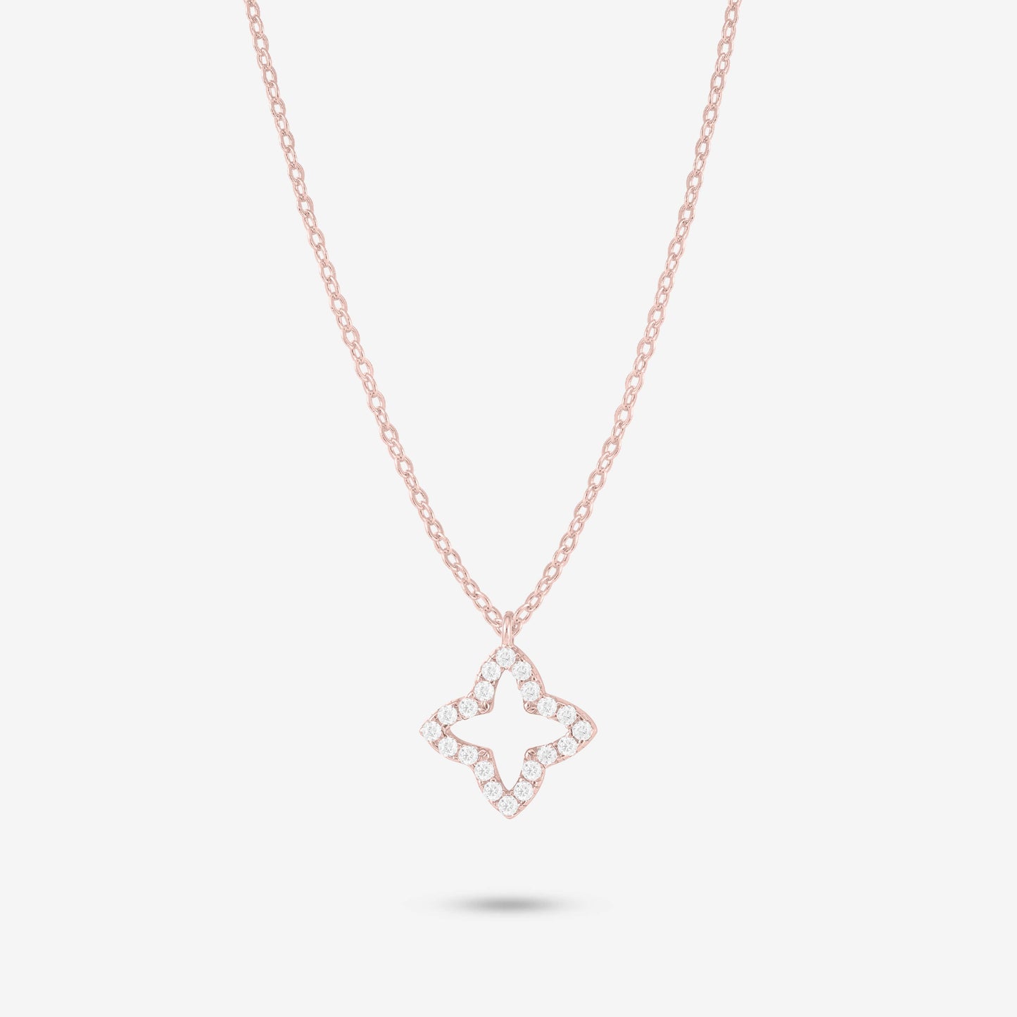 Studio shot of the Rose Gold Eden Necklace featuring a four-petal floral pendant adorned with moissanites on a delicate rose gold chain against a light grey background
