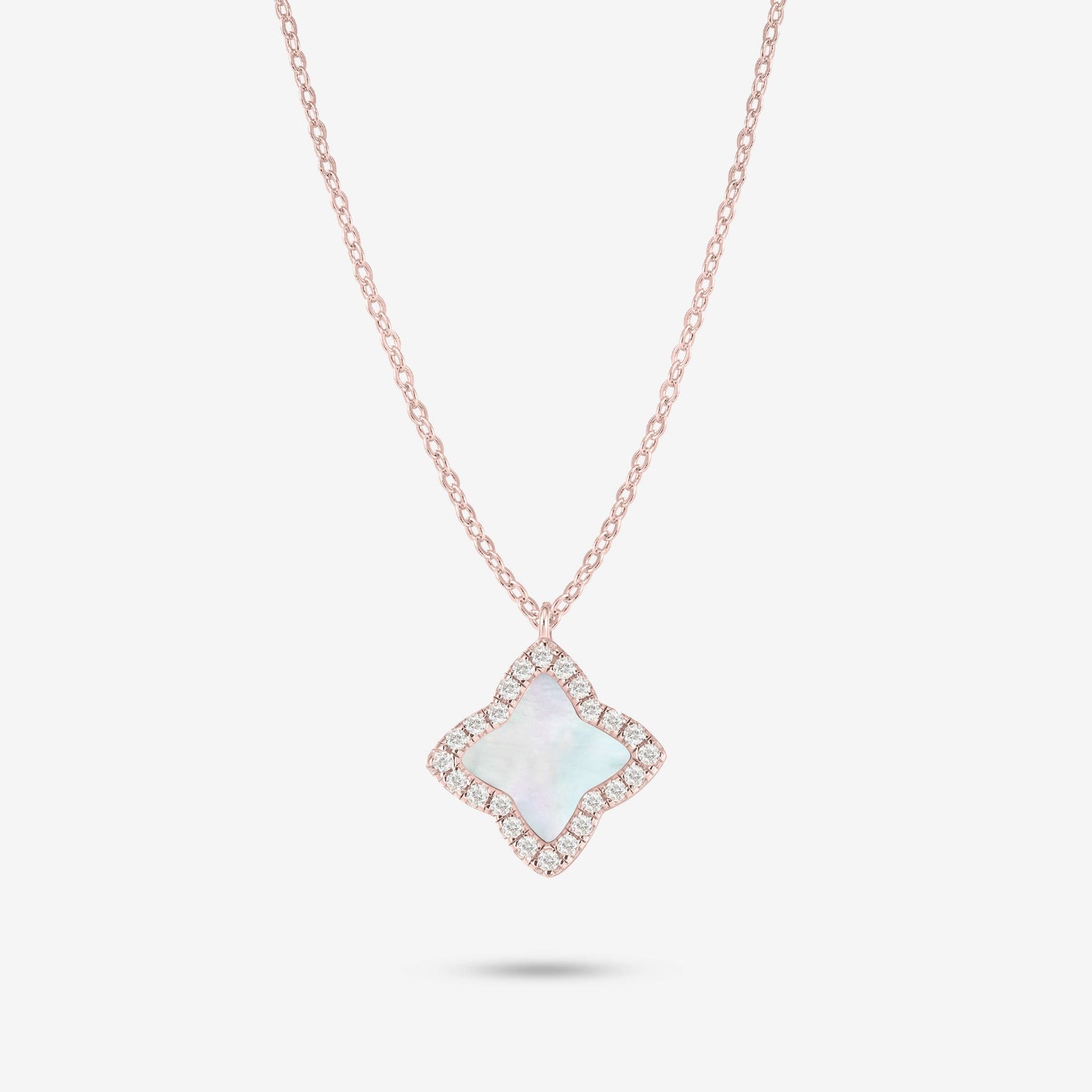 Studio shot of the Rose Gold Edea Necklace displaying a four-petal flower pendant highlighted by a mother-of-pearl center and moissanite border against light grey background