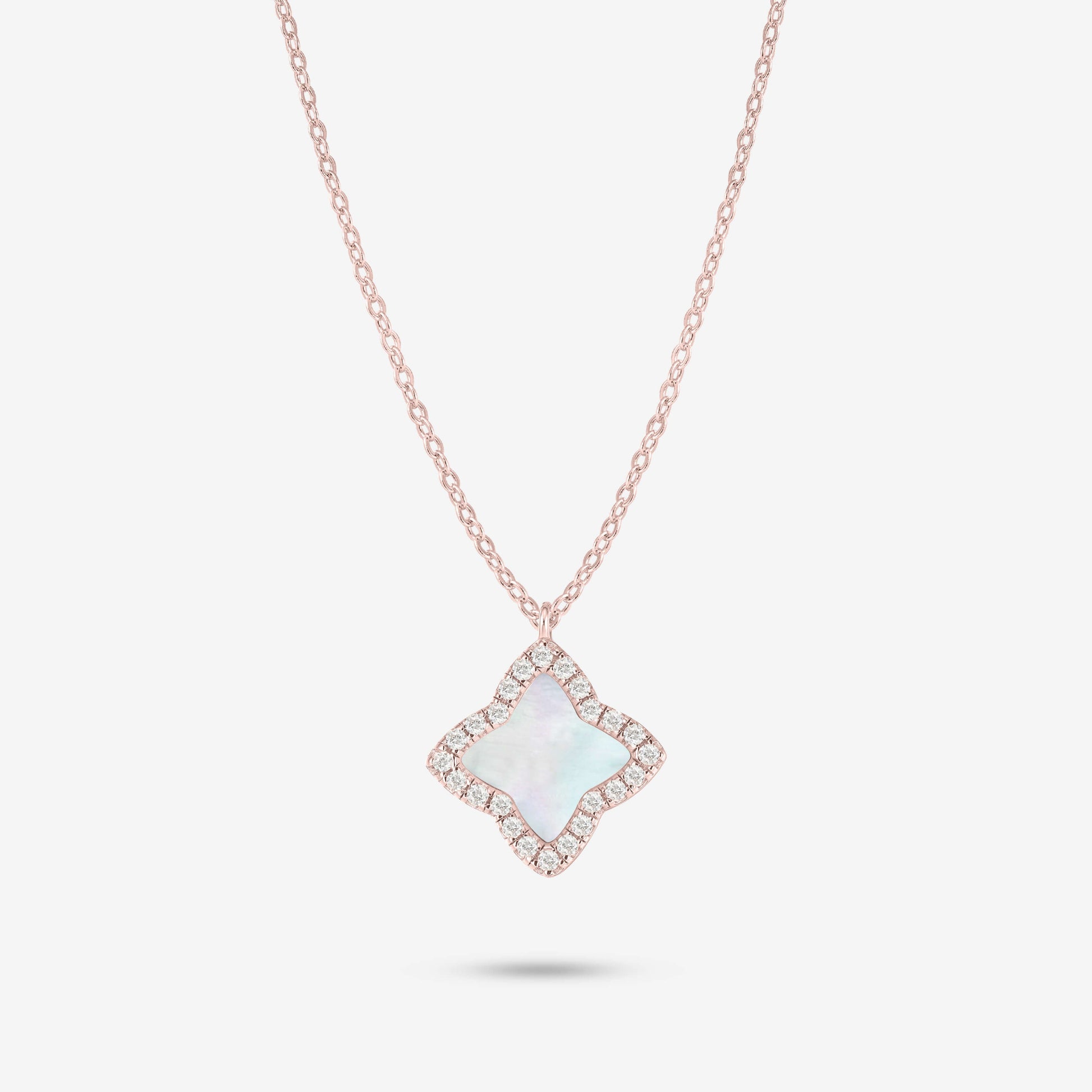 Studio shot of the Rose Gold Edea Necklace displaying a four-petal flower pendant highlighted by a mother-of-pearl center and moissanite border against light grey background