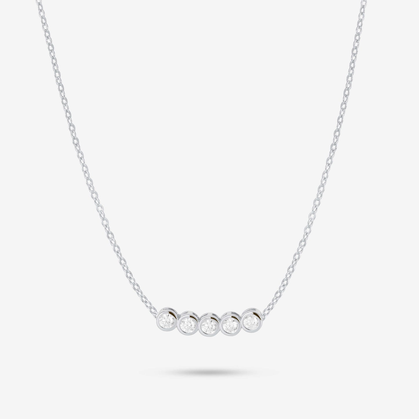 Studio shot of the Silver Dawn Necklace showcasing five bezel-set moissanites in a straight row on a slender silver chain, presented on a pale grey background