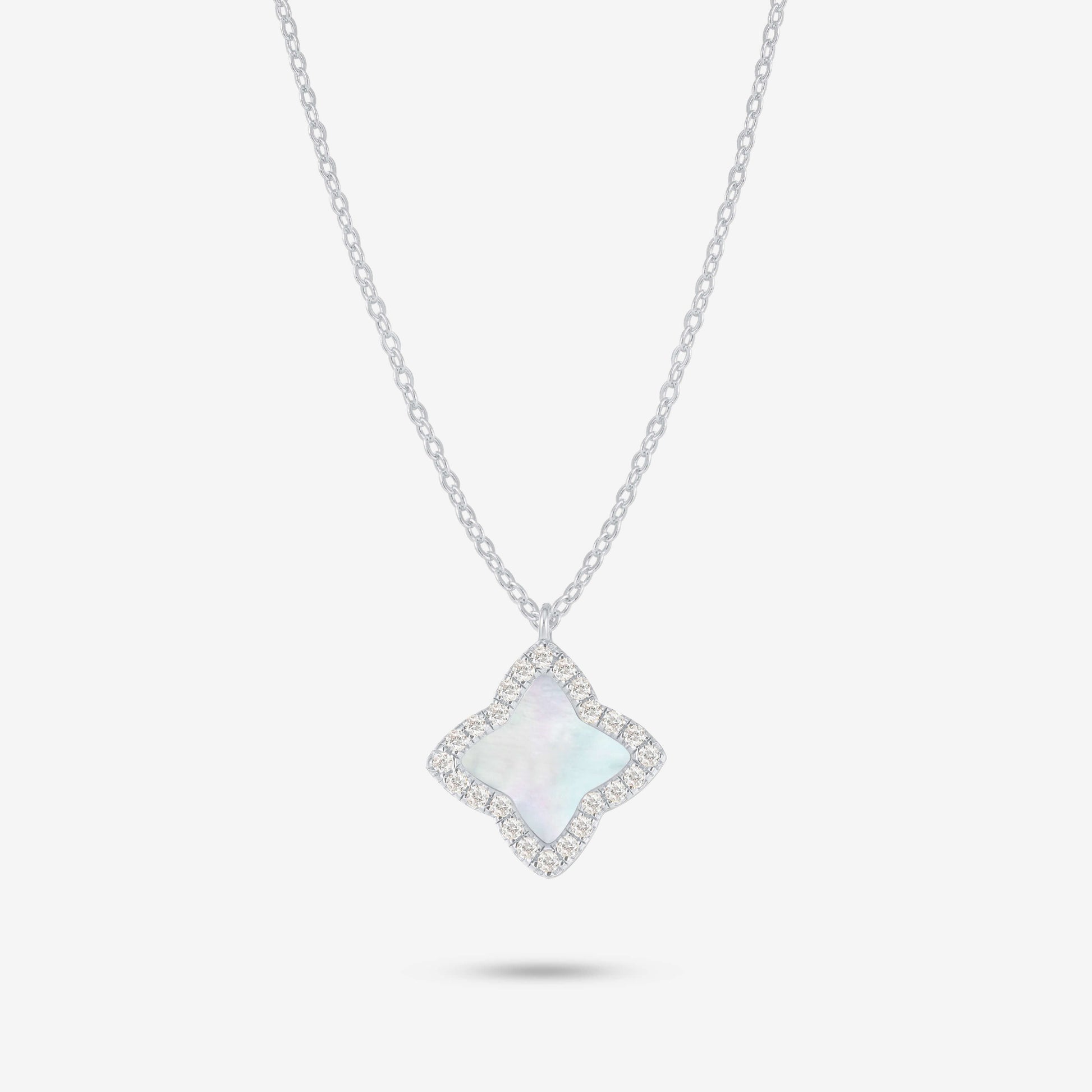 Studio shot of the Silver Edea Necklace featuring a quatrefoil pendant with mother-of-pearl inlay surrounded by moissanites on a light grey background