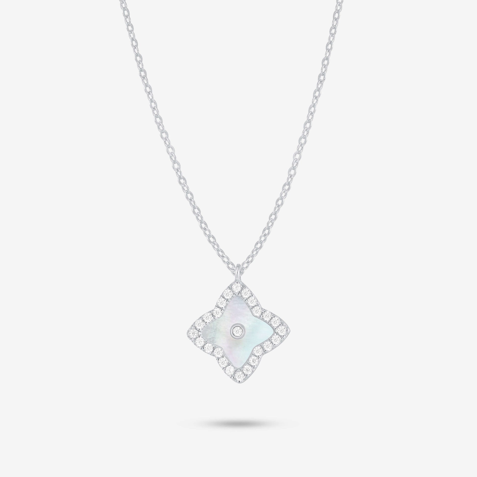 Studio shot of the Silver Irida Necklace with a quatrefoil mother-of-pearl pendant, moissanite halo, and bezel-set center stone on a grey background.