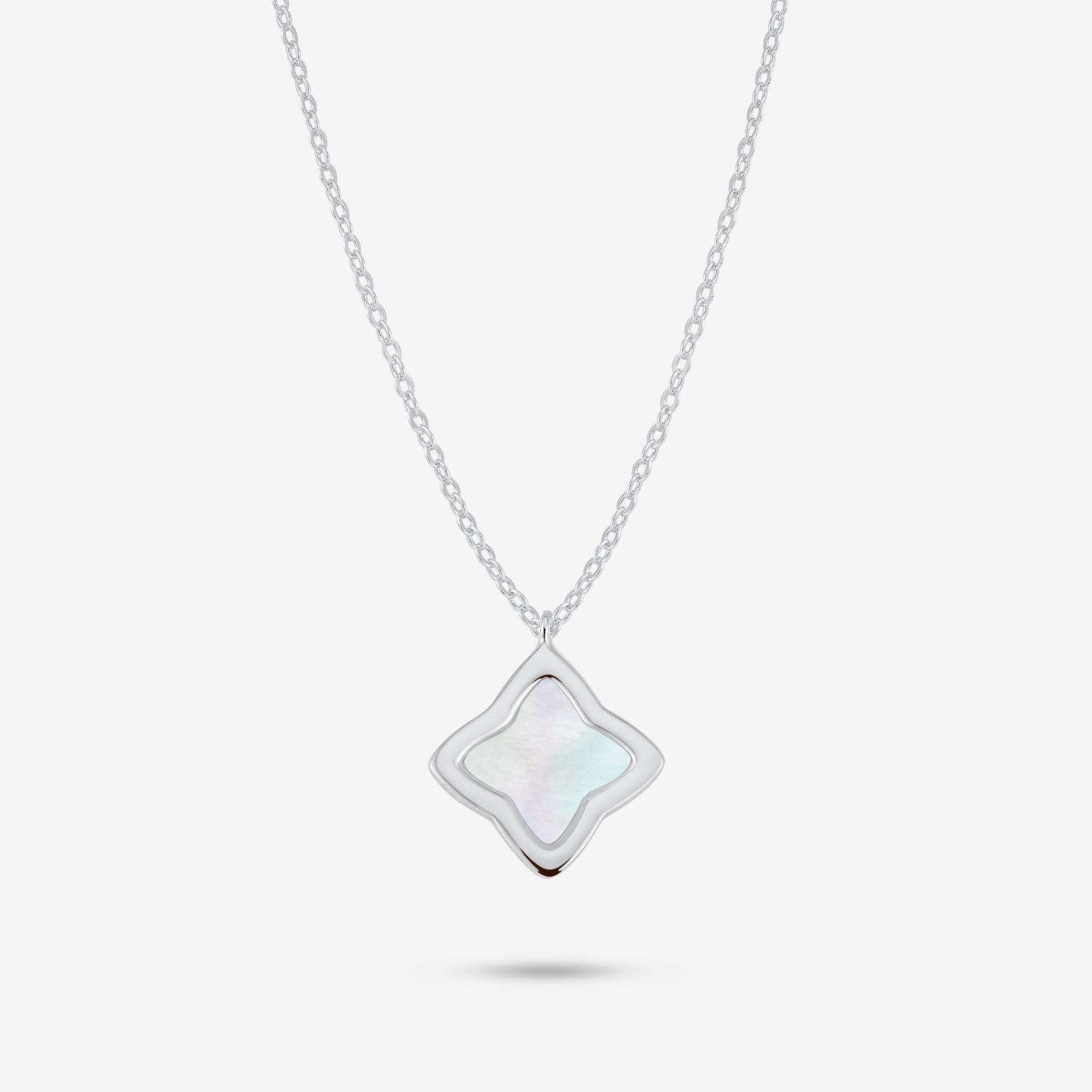 Studio shot of the Silver Creia Necklace with a clover-shaped pendant and mother-of-pearl inlay on a grey background