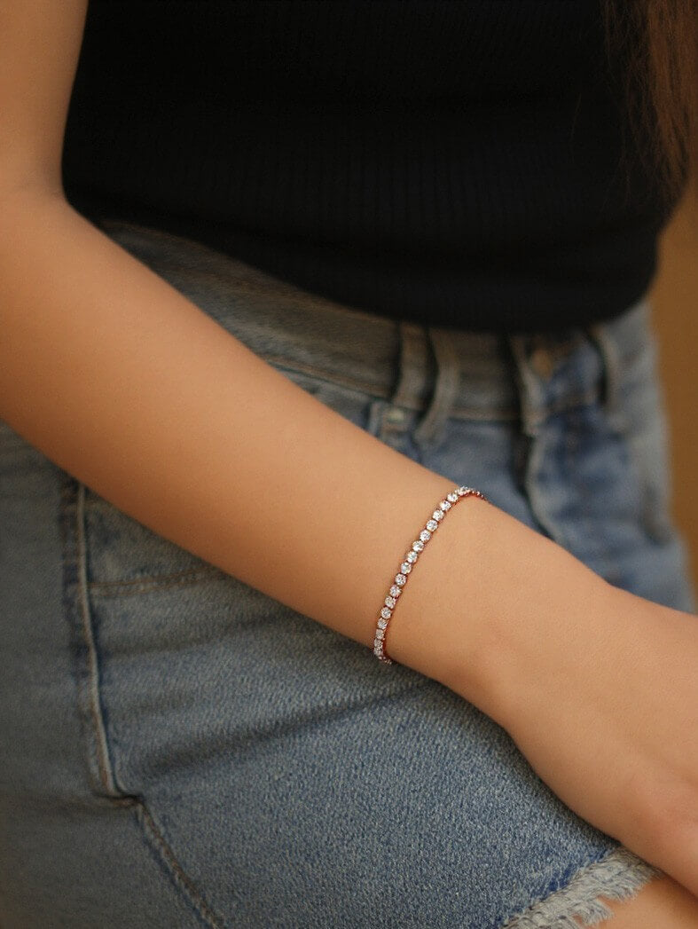 Model’s arm styled with the dazzling 18k rose gold Bold tennis bracelet, featuring larger stones that contrast beautifully with her everyday denim and black top.