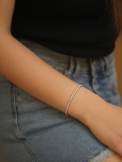 Model’s arm styled with the dazzling 18k rose gold Bold tennis bracelet, featuring larger stones that contrast beautifully with her everyday denim and black top.