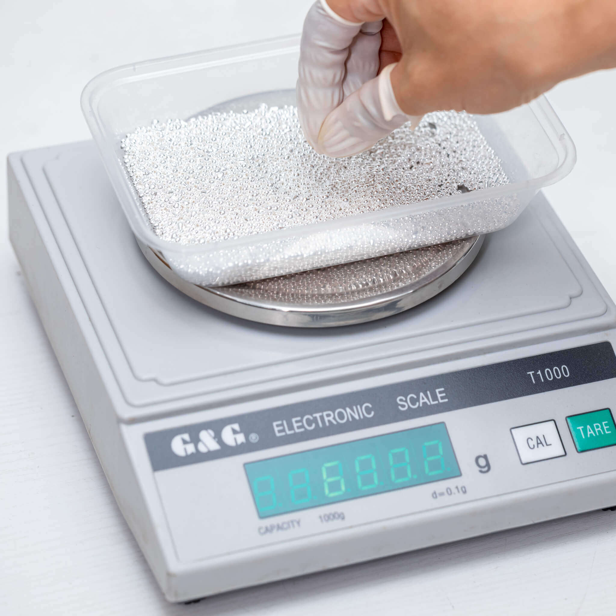 999 fine silver grain being weighed during the creation of premium 925 sterling silver alloy used in demi-fine jewellery