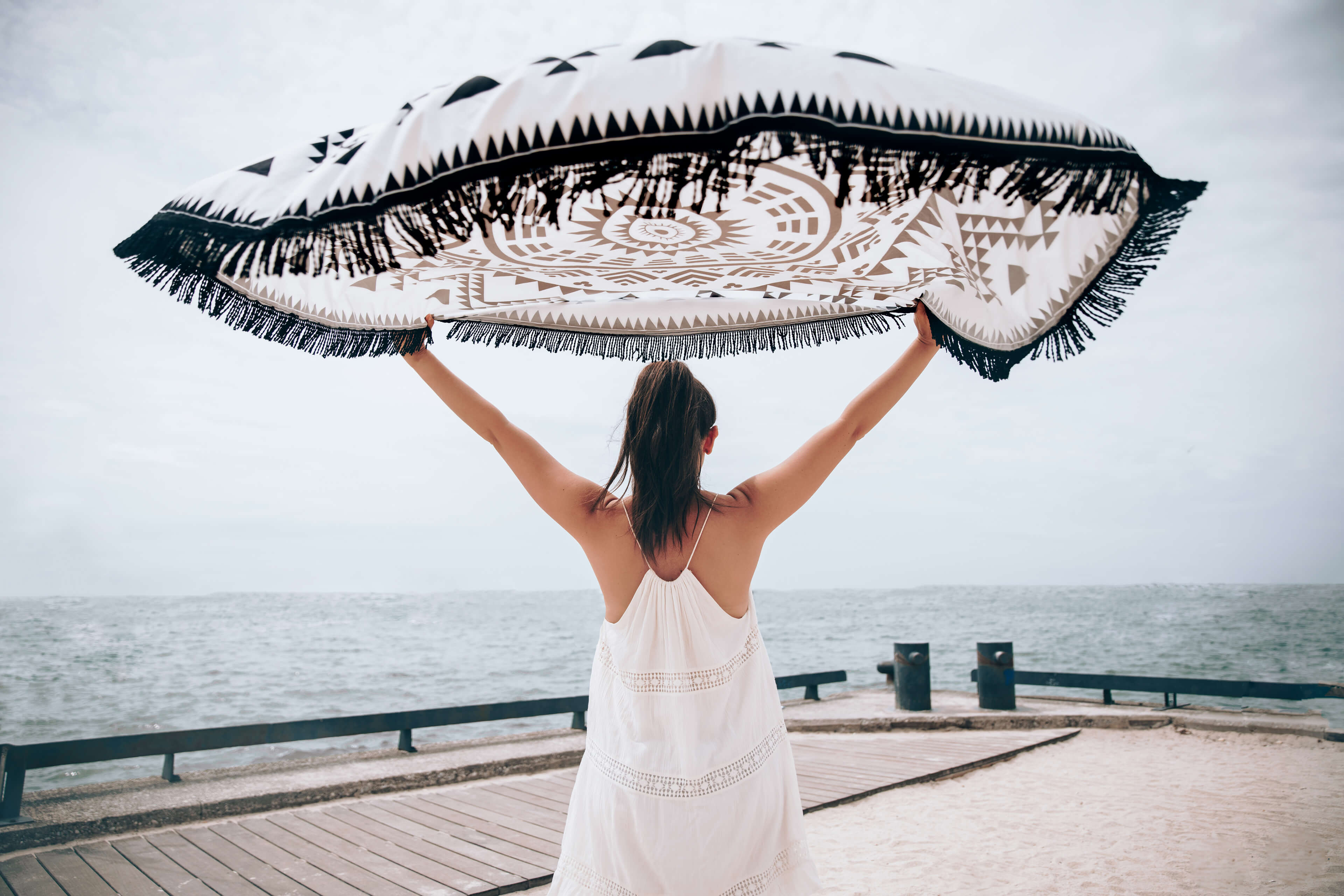 A woman enjoys a carefree day at the beach, embodying the freedom of wearing our hypoallergenic jewellery that's safe for sensitive skin.